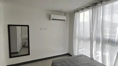 a mirror in a white room with a window at Vista de la capital in San Salvador