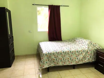 a bedroom with a bed and a window at Conchita House Playa El Tunco in Tamanique
