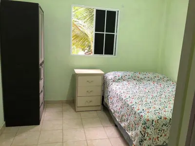 a bedroom with a bed and a dresser and a window at Conchita House Playa El Tunco in Tamanique