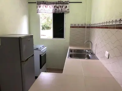 a small kitchen with a sink and a window at Conchita House Playa El Tunco in Tamanique