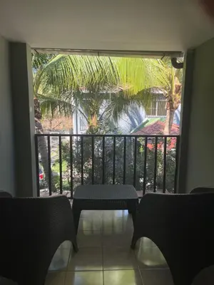 a balcony with a table and a palm tree at Conchita House Playa El Tunco in Tamanique