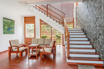 a staircase in a home with chairs and a table at Las Golondrinas El Zonte, El Salvador in El Zonte