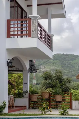 a house with a balcony and a swimming pool at Las Golondrinas El Zonte, El Salvador in El Zonte