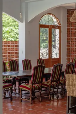 a dining room with a table and chairs and a window at Las Golondrinas El Zonte, El Salvador in El Zonte