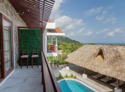 a view from the balcony of a resort with a swimming pool at Las Golondrinas El Zonte, El Salvador in El Zonte