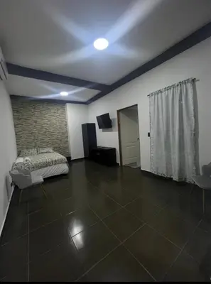 a living room with a bed and a tiled floor at Mini Apartamento in Nueva San Salvador