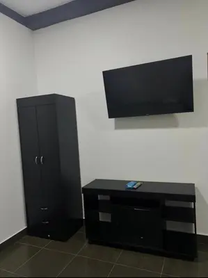 a black cabinet with a flat screen tv on a wall at Mini Apartamento in Nueva San Salvador