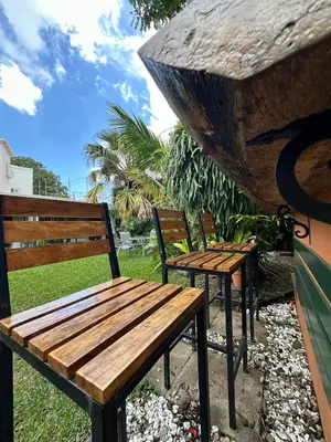 a wooden bench and two chairs in a park at Casa Santa Elena Fuertevli in San Salvador