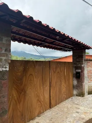 a wooden gate in a house with a roof at Villa San Carlos in Juayúa