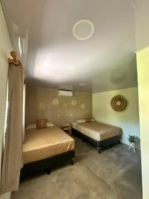 a bedroom with two beds and a ceiling at Surfcity Townhouse in La Libertad