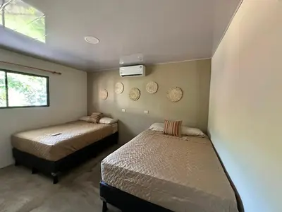 a bedroom with two beds and a window at Surfcity Townhouse in La Libertad