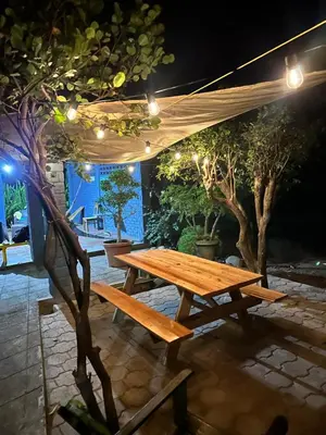 a wooden picnic table under a tent at night at Surfcity Townhouse in La Libertad