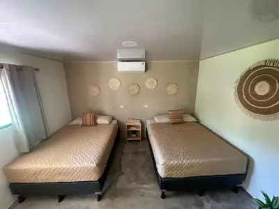 a room with two beds in a room with a fan at Surfcity Townhouse in La Libertad