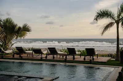 a group of chairs sitting next to the beach at Cardedeu Residence Cangrejera in La Libertad