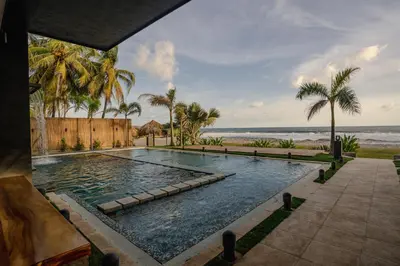 a swimming pool with the beach in the background at Cardedeu Residence Cangrejera in La Libertad