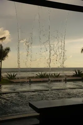 a fountain on the beach with the ocean in the background at Cardedeu Residence Cangrejera in La Libertad