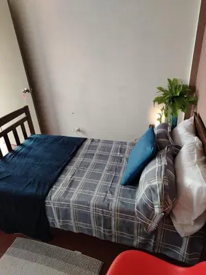 a bedroom with a bed with blue sheets and pillows at Hostal Genoveva in San Salvador