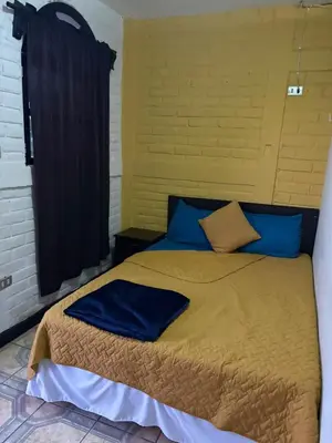 a bedroom with a large bed with blue pillows at El Balcón de Ataco in Concepción de Ataco
