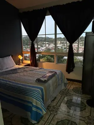 a bedroom with a bed and a large window at El Balcón de Ataco in Concepción de Ataco