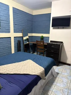 a bedroom with a bed and a table and a tv at El Balcón de Ataco in Concepción de Ataco