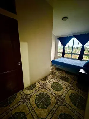 a bedroom with a bed with a window and a rug at El Balcón de Ataco in Concepción de Ataco