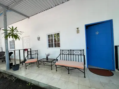 two benches sitting on a patio with a blue door at La ceiba surf in El Sunzal
