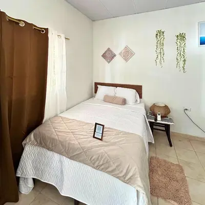 a bedroom with a bed with a tablet on it at La ceiba surf in El Sunzal