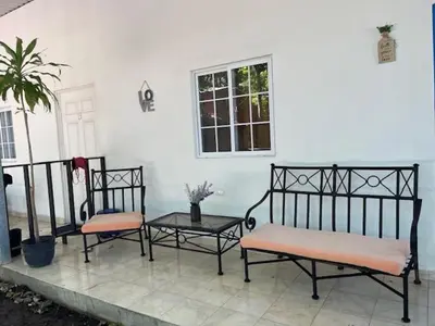 two benches and a table in front of a house at La ceiba surf in El Sunzal