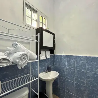 a bathroom with a sink and a toilet and a mirror at La ceiba surf in El Sunzal
