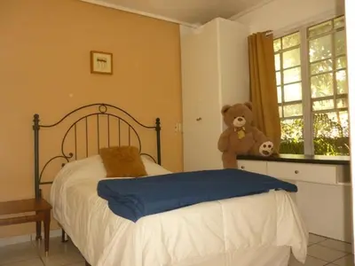 a bedroom with a bed with a teddy bear on a window at Apartment with an excellent location by Redondel Masferrer San Salvador, El Salvador in San Salvador