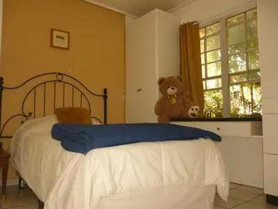 a bedroom with a bed with a teddy bear next to a window at Apartment with an excellent location by Redondel Masferrer San Salvador, El Salvador in San Salvador