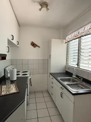 a white kitchen with a sink and a stove at Apartment with an excellent location by Redondel Masferrer San Salvador, El Salvador in San Salvador