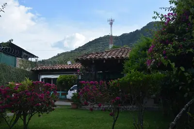 a house with flowers in a yard with a mountain at Gran Bonanza Hotel in Alegría