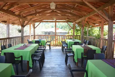 a restaurant with green tables and chairs in a pavilion at Gran Bonanza Hotel in Alegría