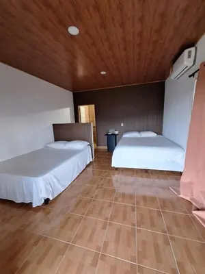 two beds in a room with a wooden ceiling at Hotel y restaurante villa marquez in Perquín