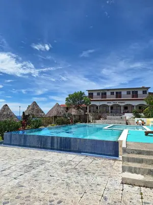 a resort swimming pool with a building in the background at Hotel y restaurante villa marquez in Perquín