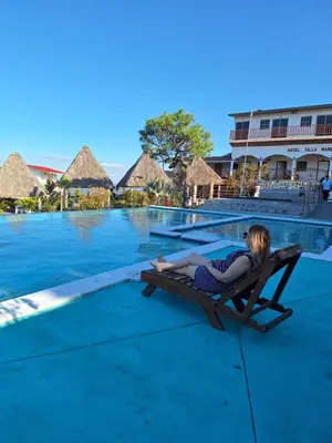 a woman laying on a chaise lounge next to a swimming pool at Hotel y restaurante villa marquez in Perquín
