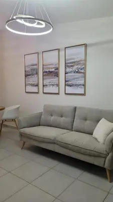 a living room with a couch and four pictures on the wall at Cozy House! San Miguel in San Miguel