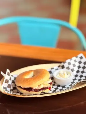 a bagel sandwich on a plate with a sauce at Casa FLamenco Suchitoto in Suchitoto