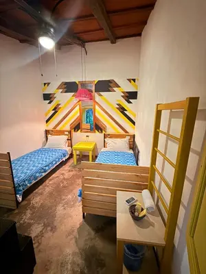 a room with three beds and a table in it at Casa FLamenco Suchitoto in Suchitoto