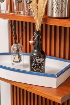 a bottle on a shelf with some grass in it at Cadejo Brewing Company El Sunzal in Tamanique