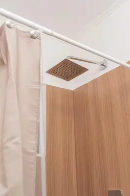 a metal rack with a shower curtain in a room at Cadejo Brewing Company El Sunzal in Tamanique