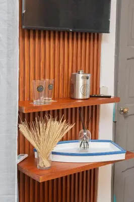 a bathroom sink on a wooden shelf with a television at Cadejo Brewing Company El Sunzal in Tamanique