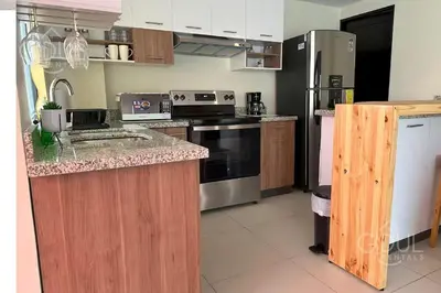 a kitchen with stainless steel appliances and wooden cabinets at Great San Salvador views at Los Planes wifi and Ac in San Salvador