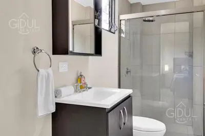 a bathroom with a white sink and a shower at Great San Salvador views at Los Planes wifi and Ac in San Salvador