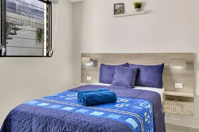a bedroom with a bed with a blue pillow on it at Great San Salvador views at Los Planes wifi and Ac in San Salvador
