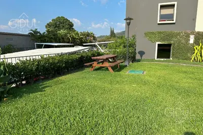 a picnic table in the grass next to a building at Great San Salvador views at Los Planes wifi and Ac in San Salvador
