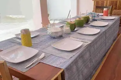 a long table with plates and utensils on it at Oceanfront Solar Paradise-Steps to the Sea in El Zapote