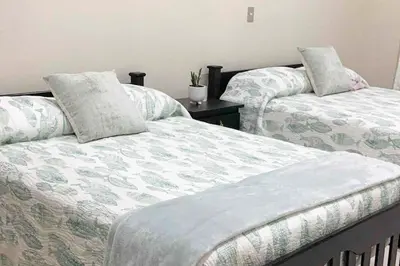 two beds sitting next to each other in a room at Oceanfront Solar Paradise-Steps to the Sea in El Zapote
