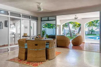 a living room with a table and wicker chairs at Oceanfront Solar Paradise-Steps to the Sea in El Zapote